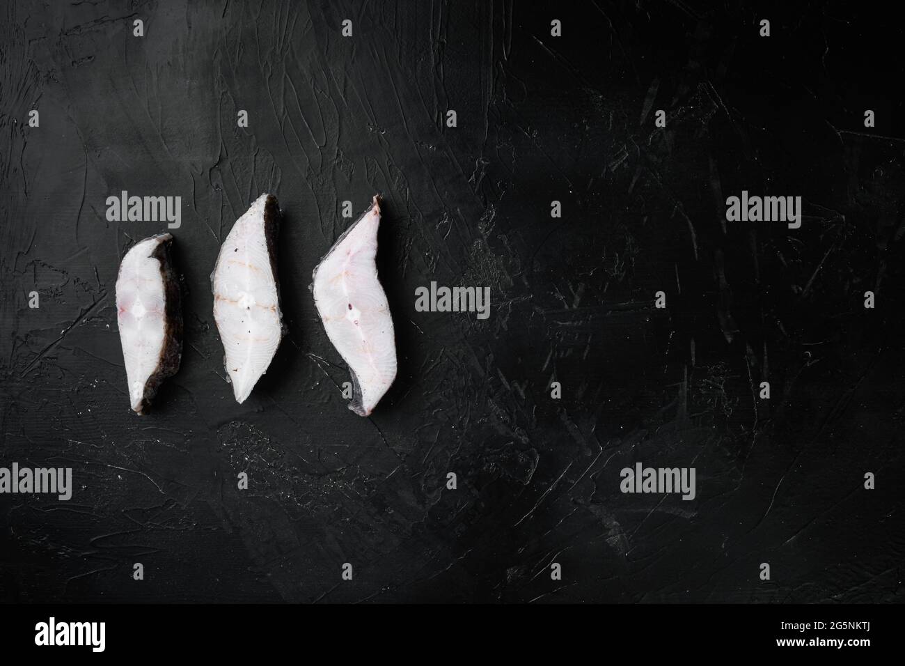 Frozen raw fish steak set, on black dark stone table background, top ...