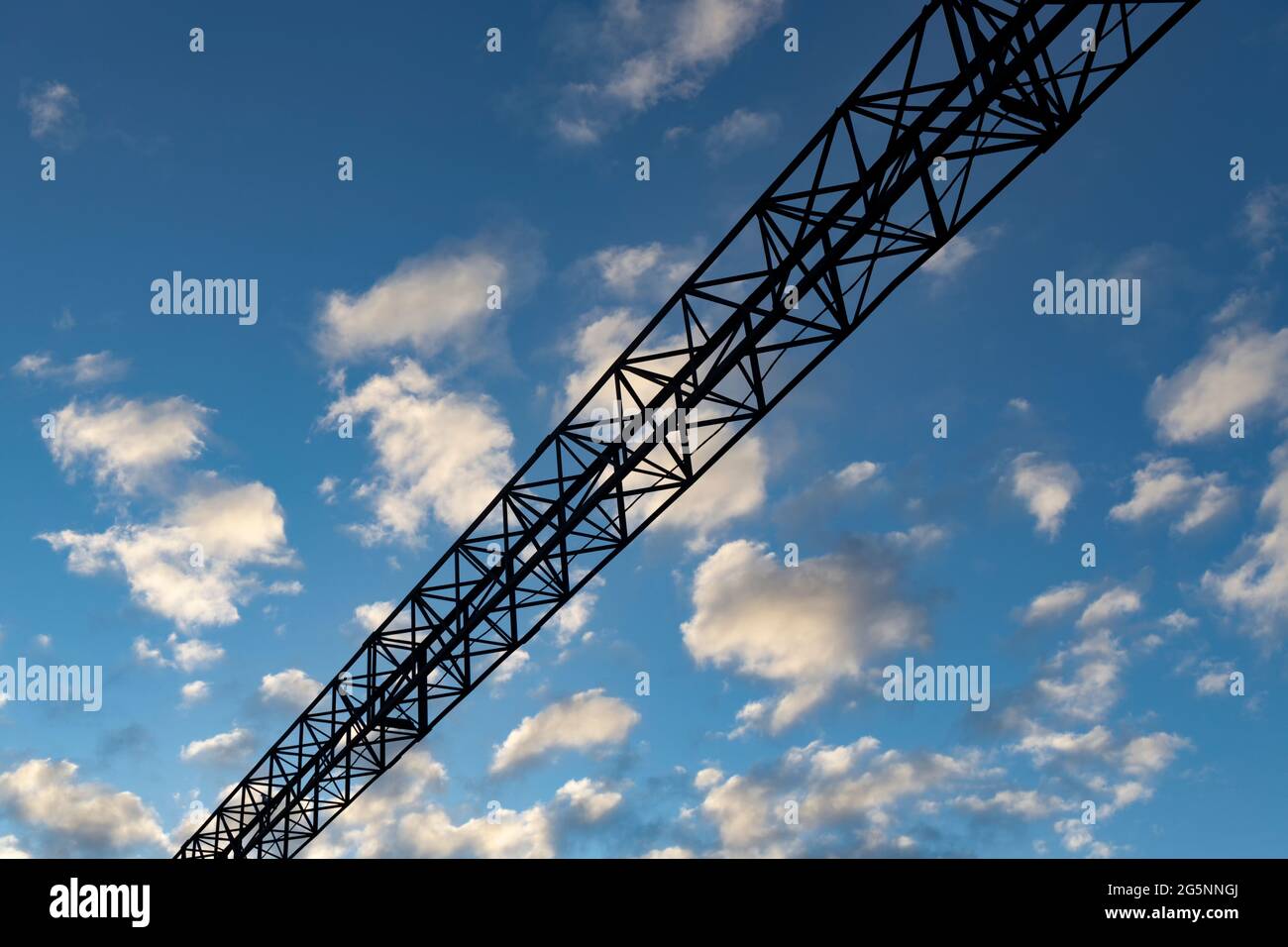 Metal beam at the top of the overall gate of the railway on a cloudy background Stock Photo