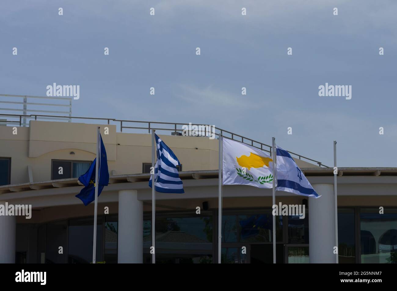 Four waving flags with visible symbols of Greece, Cyprus and Israel Stock Photo