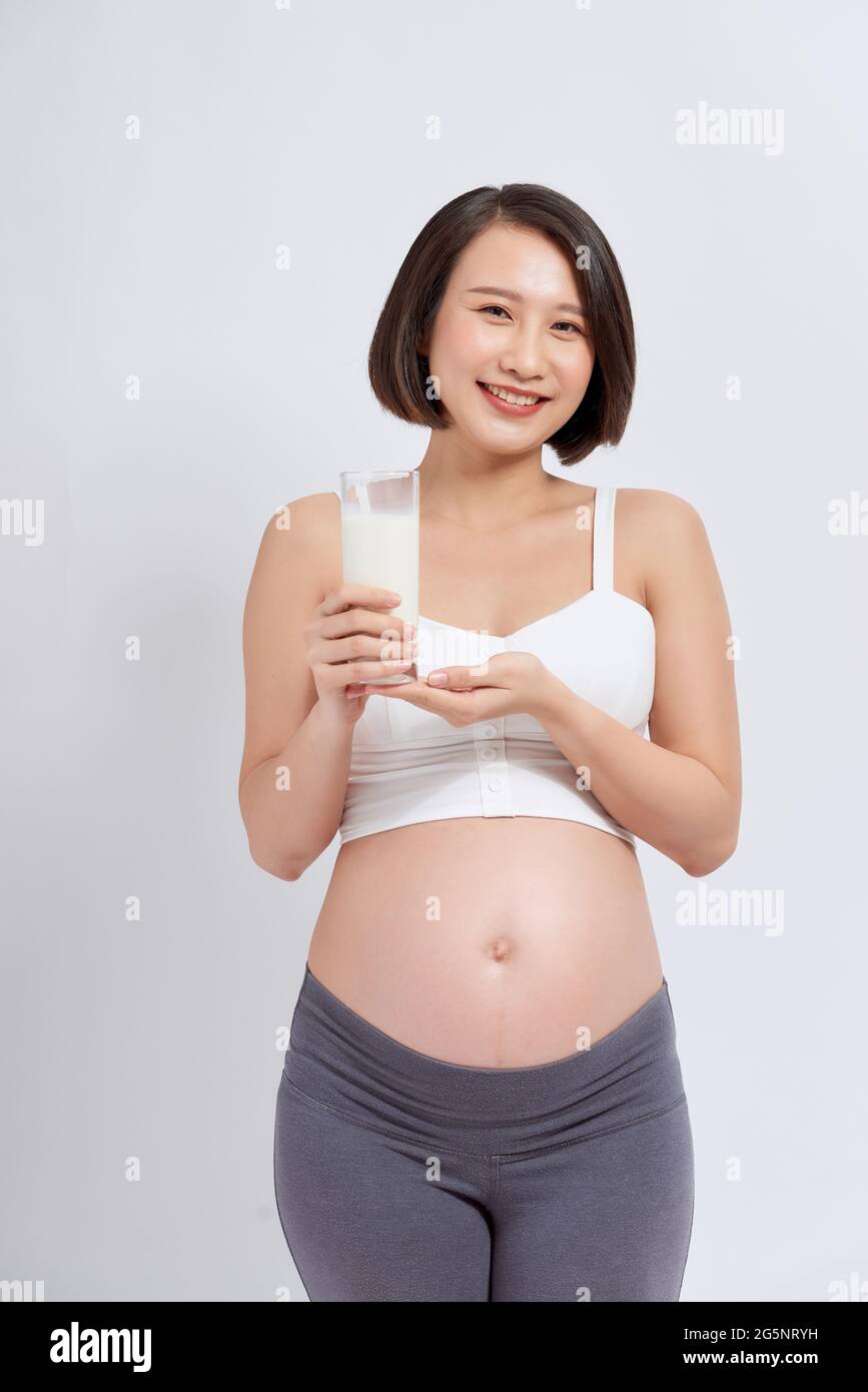 Pregnant young asian woman with a glass of milk in hand. Stock Photo