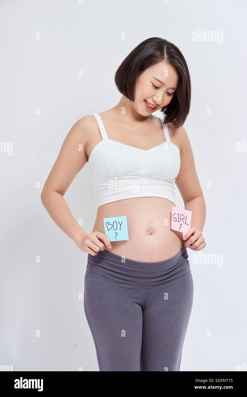 Pregnant woman with a sticky note and writing love boy or girl on sticky note and add on her belly,P Stock Photo