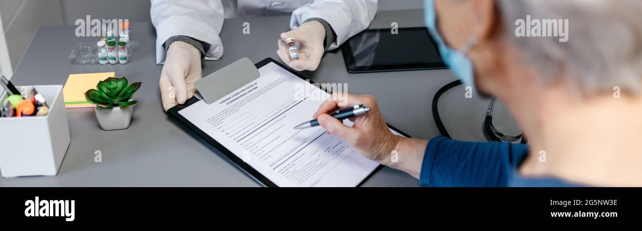 Doctor explaining to her patient the benefits and risks of the coronavirus vaccine Stock Photo