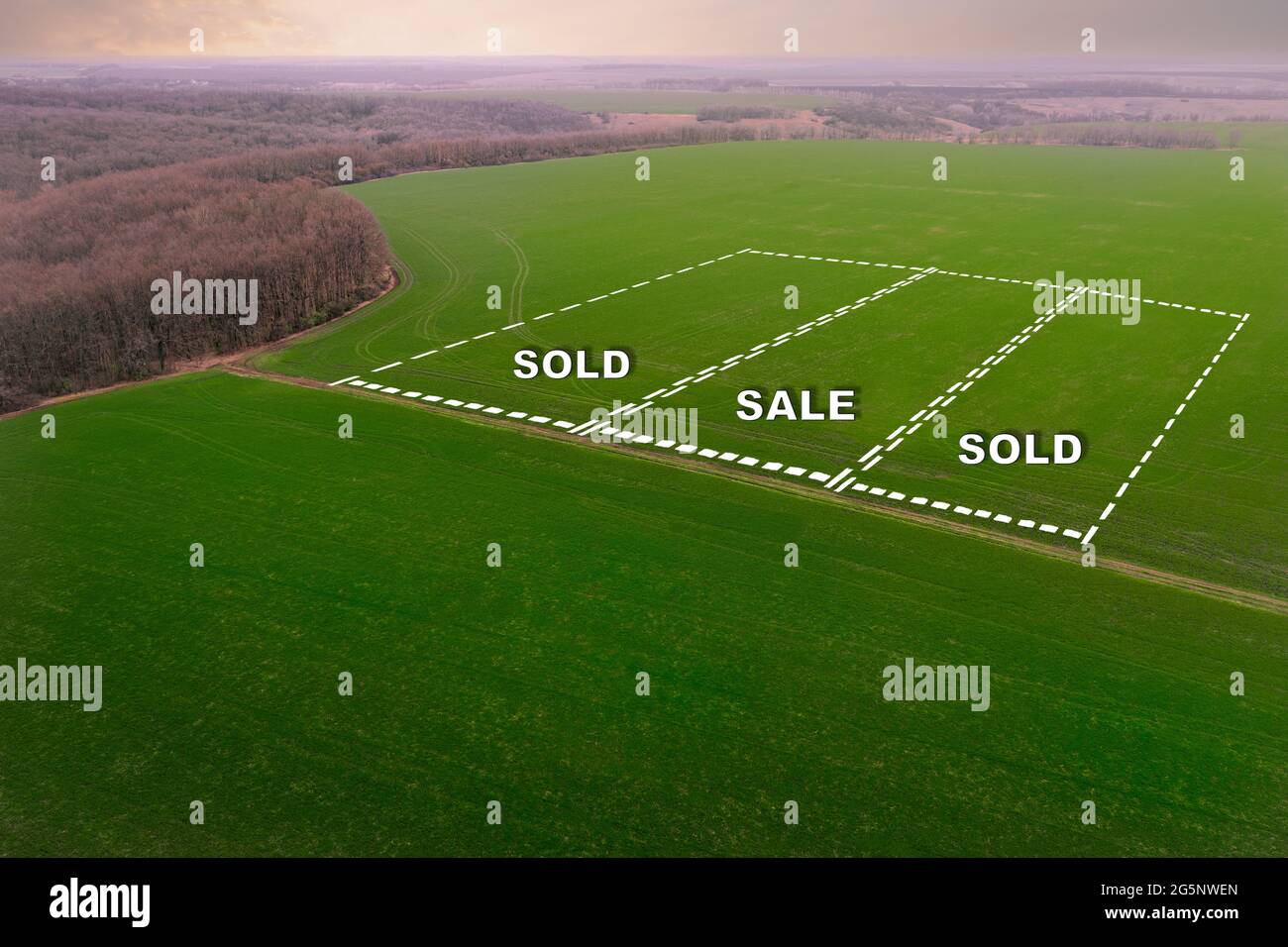 The concept of the land market for the sale of agricultural land. Farmlands for growing crops - aerial shot with the inscription Sold and Sale. Stock Photo