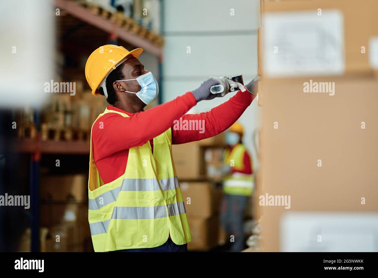 Black male worker scanning boxes in warehouse Stock Photo