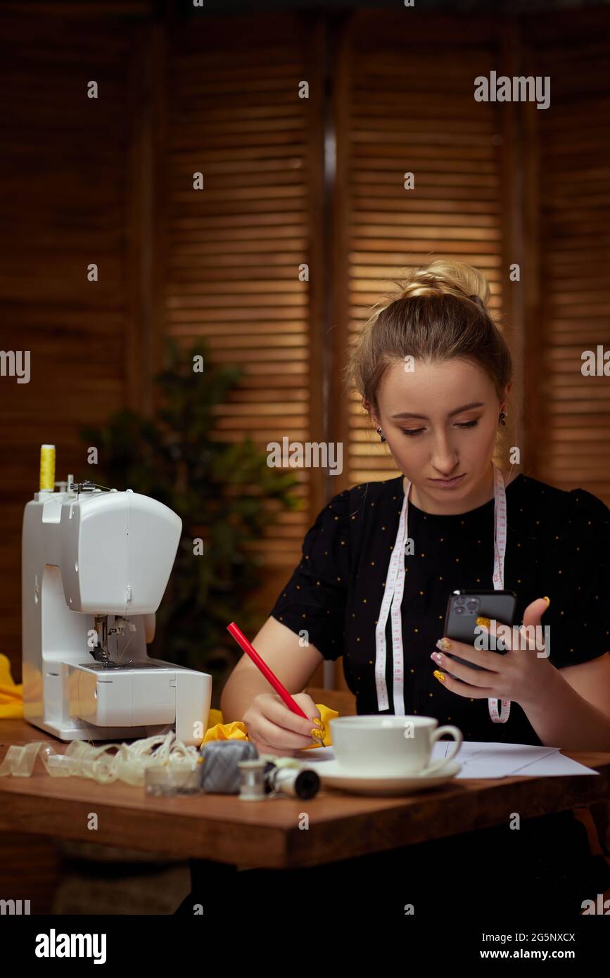 Beautiful young seamstress working on sewing machine Stock Photo