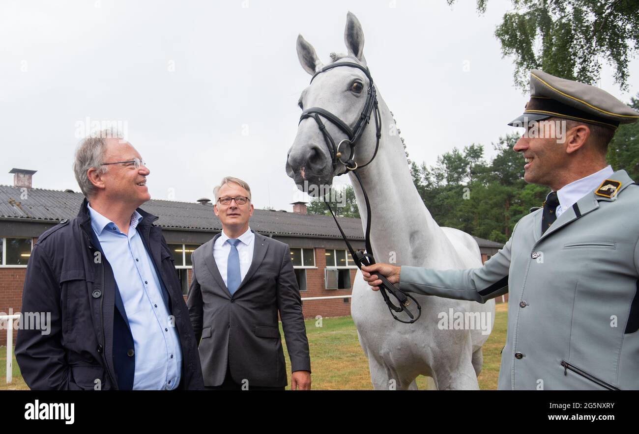 29 June 2021, Lower Saxony, Celle: Stephan Weil (l, SPD), Minister President of Lower Saxony, stands together with State Stable Master Axel Brockmann (M) and Gestüt Chief Warden Heiko Tietze next to the Hanoverian Dia Continus at the Adelheidsdorf Stallion Testing Station of the State Stud Celle. The visit is part of the program of the second day of his three-day summer tour through Lower Saxony. Photo: Julian Stratenschulte/dpa Stock Photo