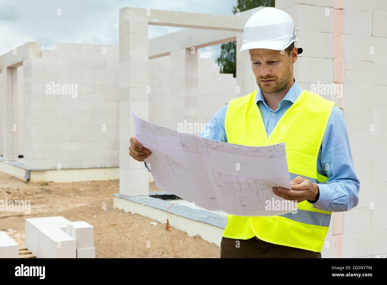 architect working with blueprints at construction site. project control and supervision Stock Photo
