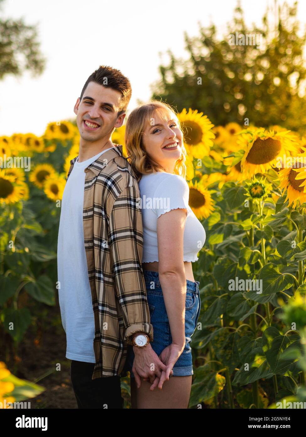 Portrait of a smiling multiethnic couple standing isolated over yellow  background, covering eyes of his girlfriend Stock Photo - Alamy