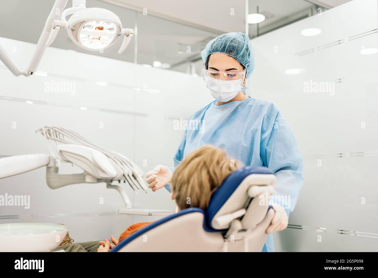 Dentist wearing protective face mask and disposable hair net working