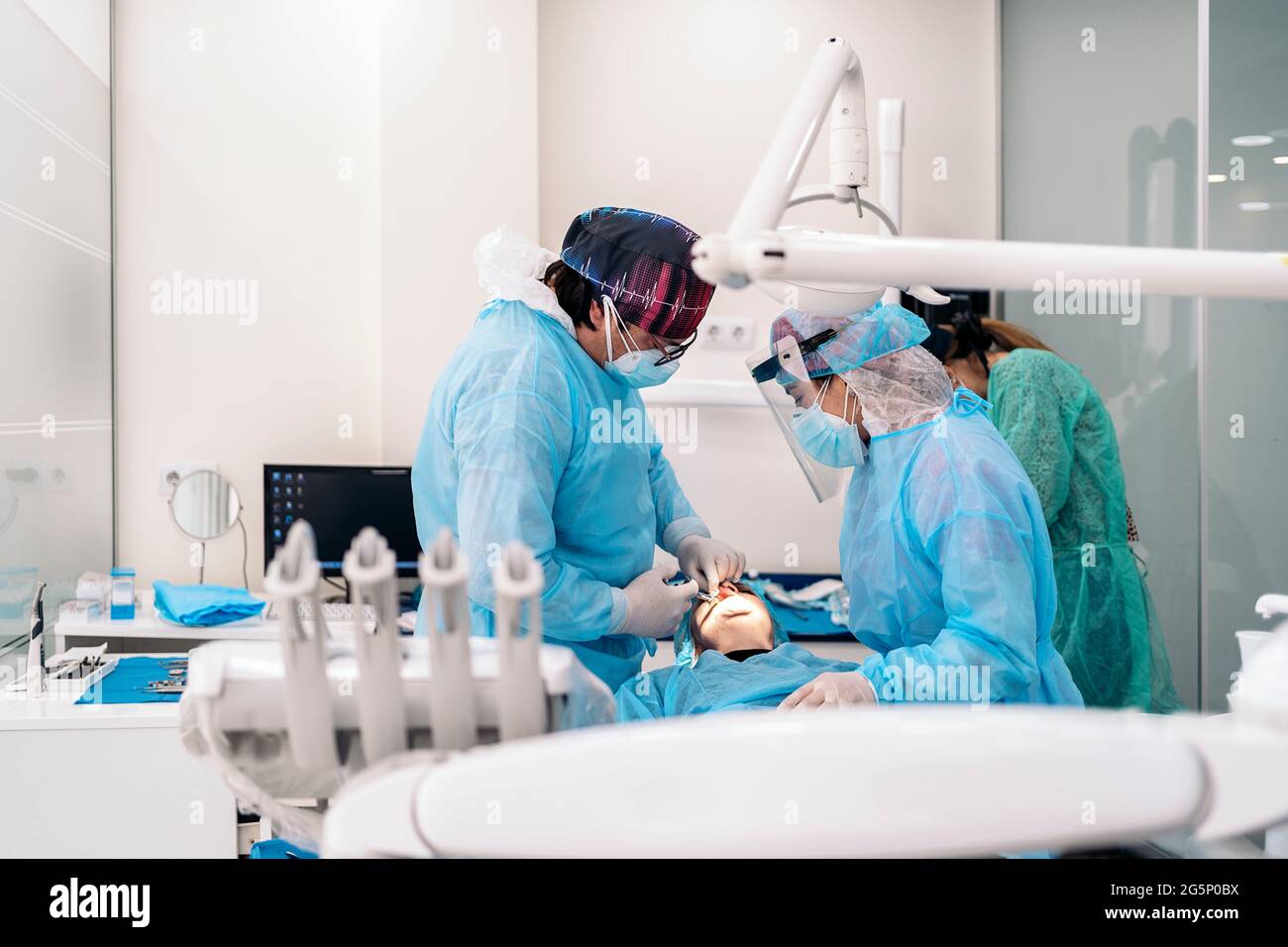 Dentist work team wearing face mask and protective clothes working with