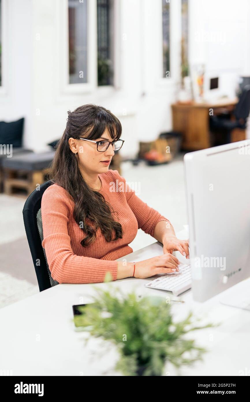 Focused office worker using computer and working in the office. Co-working concept. Stock Photo