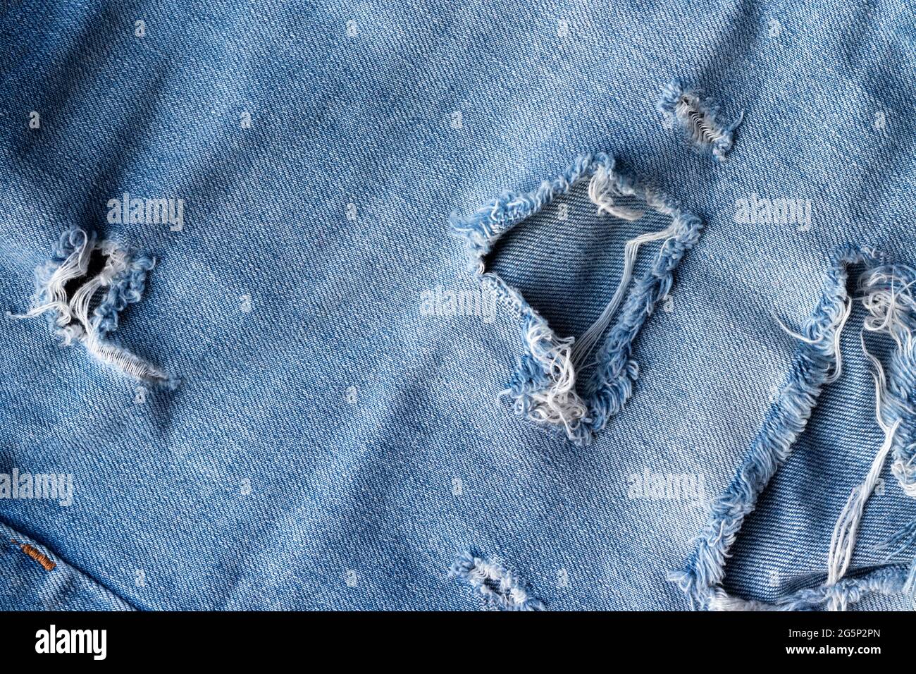 Blue torn jeans fabric texture. Distressed denim with hole and seam  background Stock Photo - Alamy