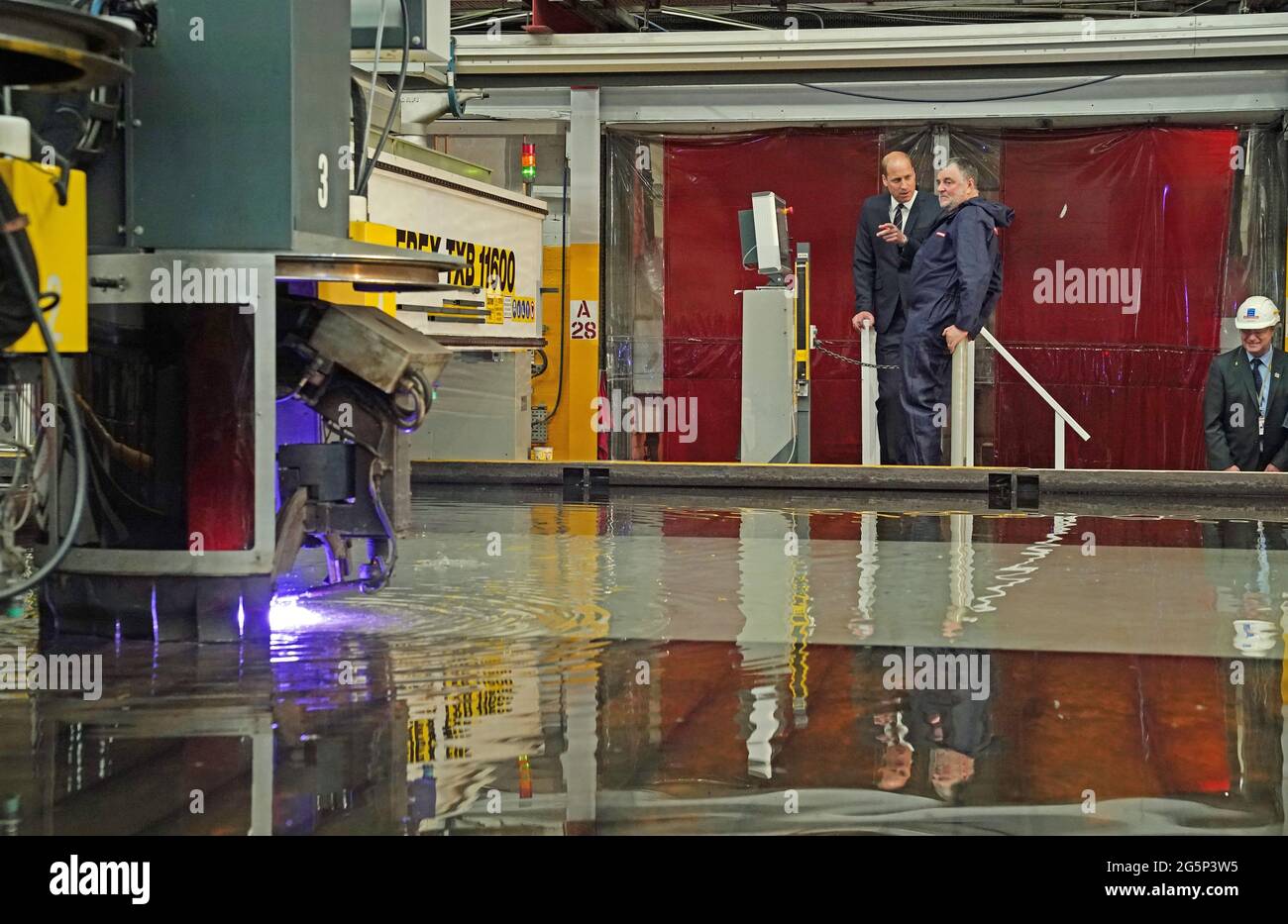 The Duke of Cambridge, known as the Earl of Strathearn in Scotland, watches with Alex Clark during a steel-cutting ceremony while on a visit to the BAE Systems shipyard in Glasgow to see construction on HMS Glasgow - the Royal Navy's first City-class Type 26 frigate. Picture date: Tuesday June 29, 2021. Stock Photo