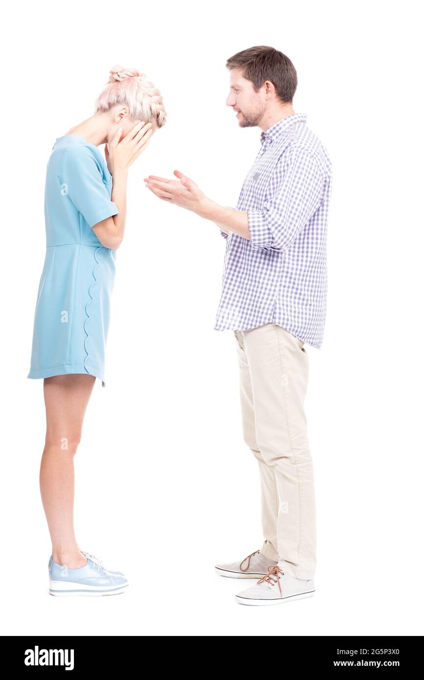 Vertical full length side view studio shot of man comforting his sad wife crying about something, white background Stock Photo