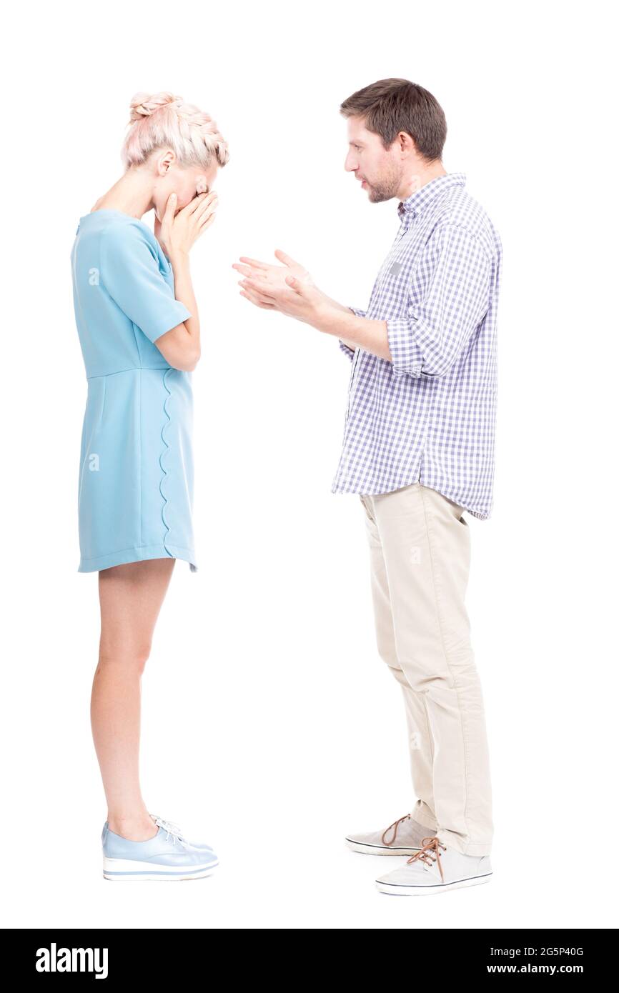 Vertical full length side view studio shot of man comforting his sad wife crying about something, white background Stock Photo