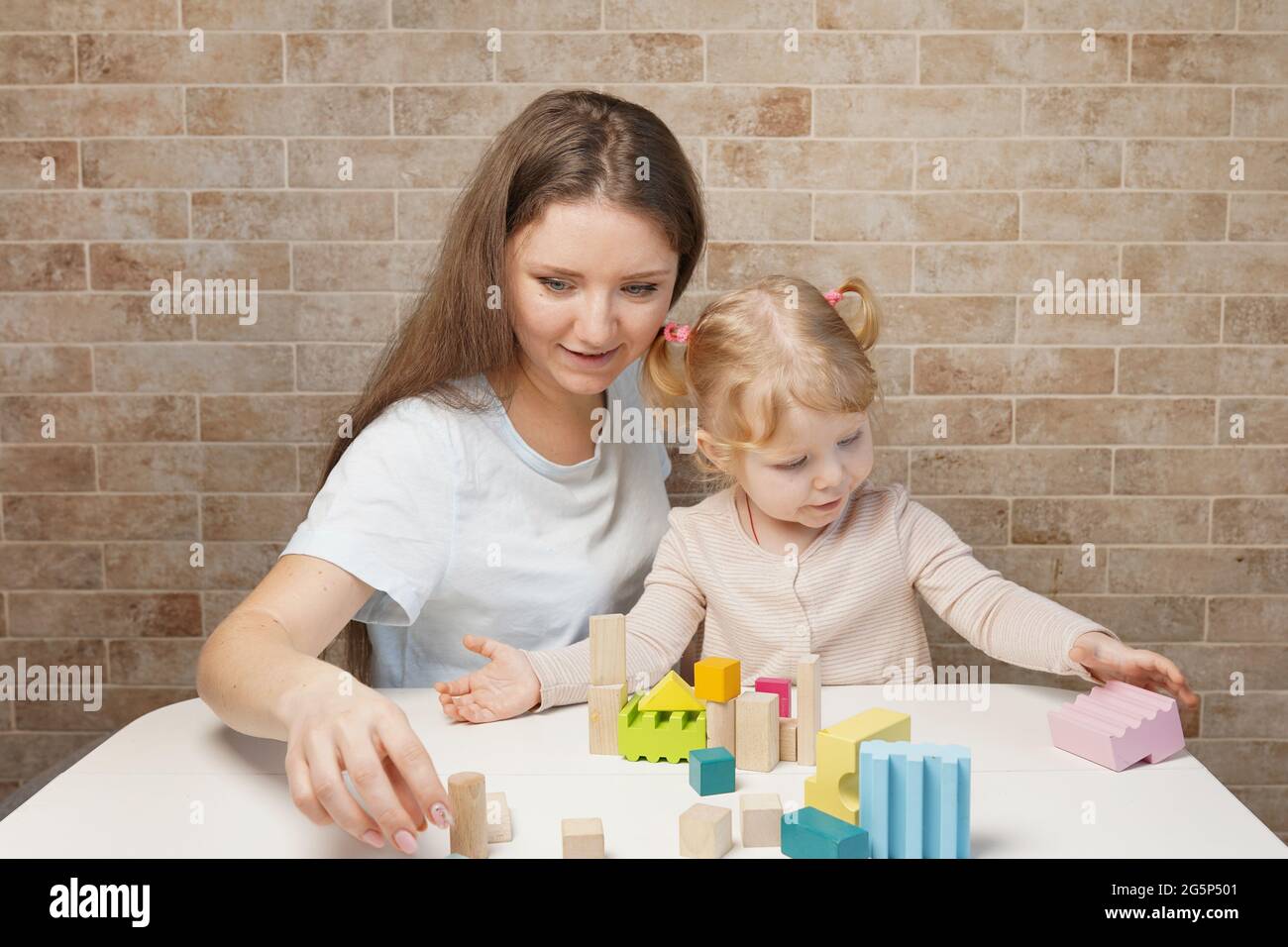 Mother with a child playing with wooden blocks at home Stock Photo - Alamy