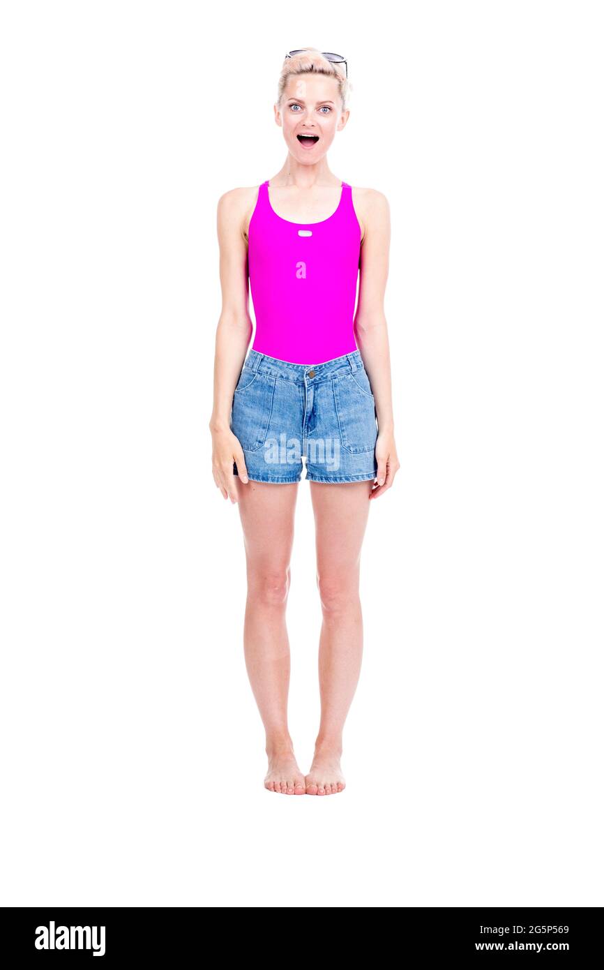 Vertical full length studio portrait of young Caucasian woman wearing summer outfit amused with something, white background Stock Photo