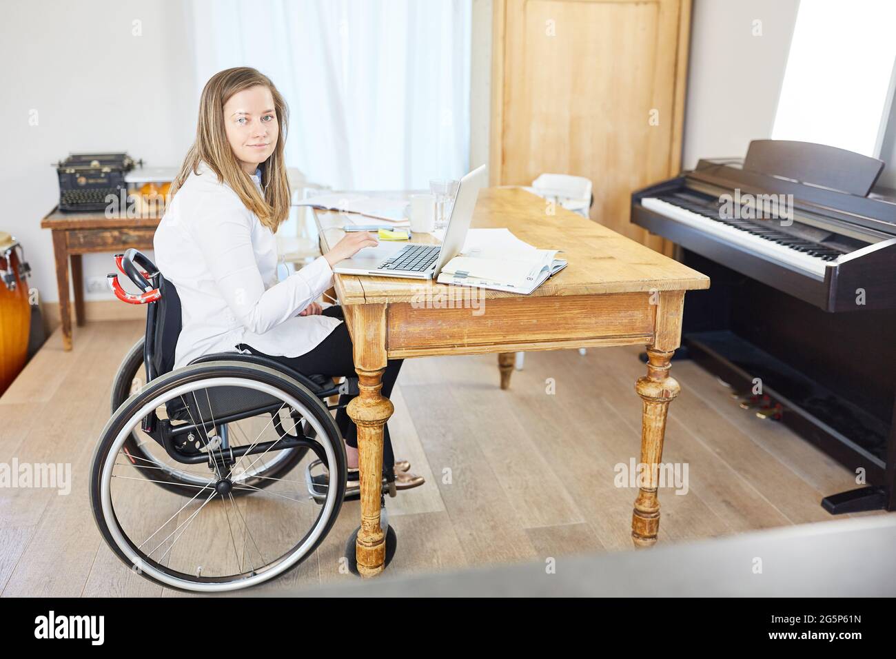 Business woman with disability in wheelchair working on laptop computer