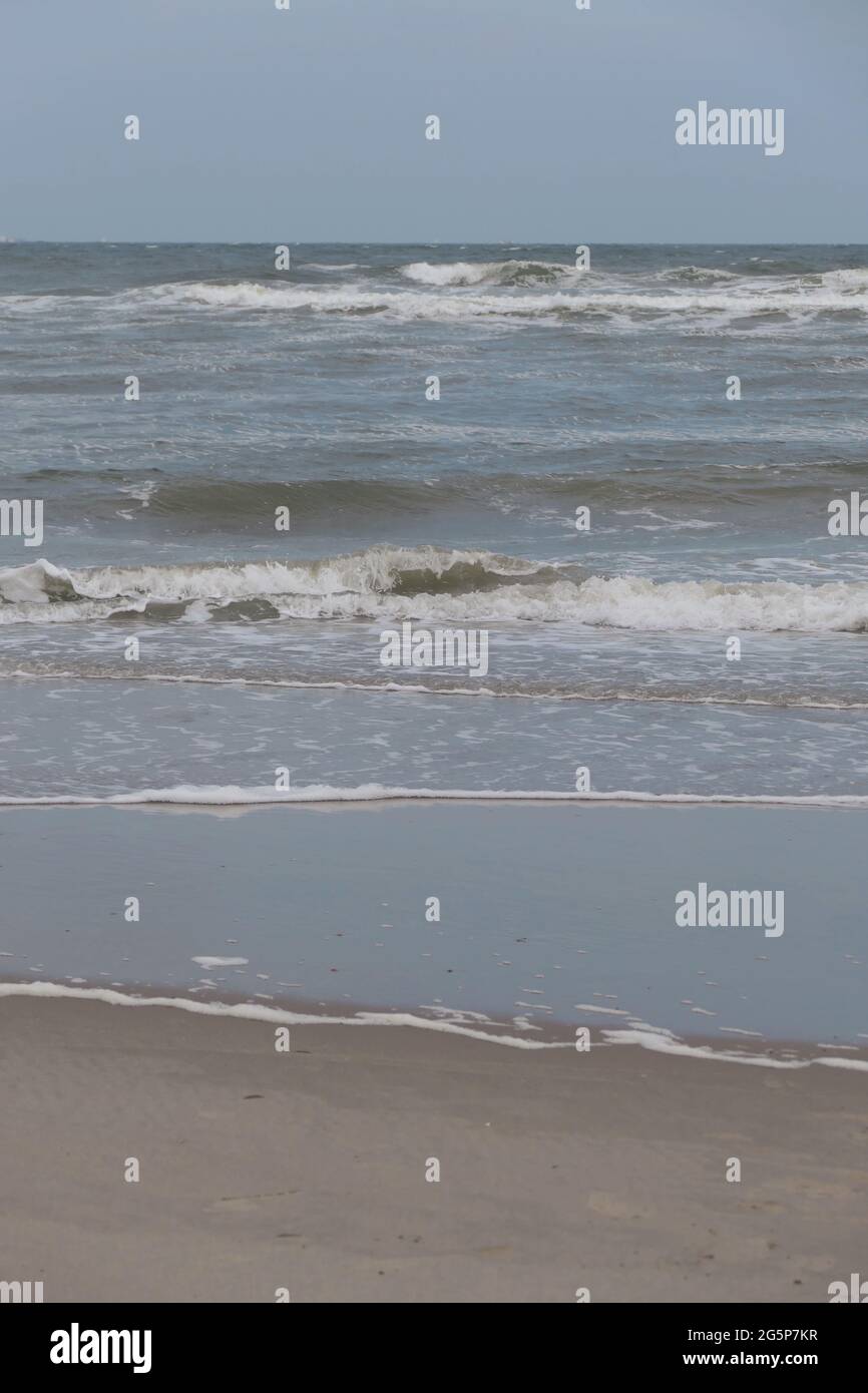 Waves breaking onto a sandy beach Stock Photo