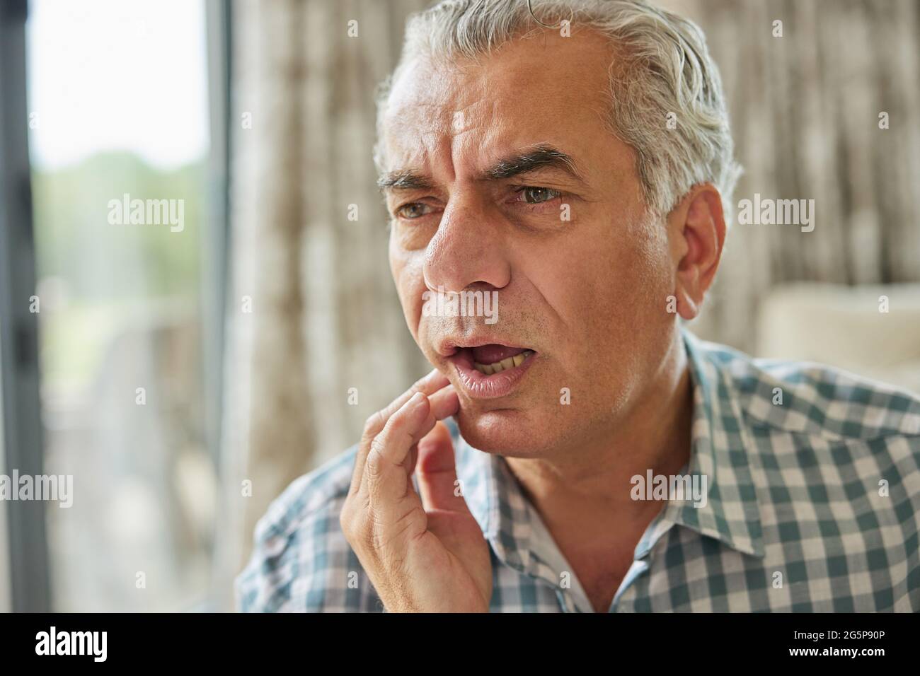 Mature Man At Home Suffering From Pain With Toothache Stock Photo