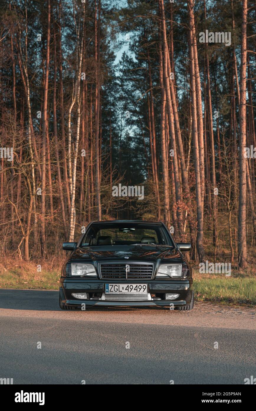 Goleniow, Poland - April 20th, 2021: Old black tuned Mercedes Benz C-class ( W202 model) near forest. Compact luxury sedan icon from the 90s. Vertical  Stock Photo - Alamy