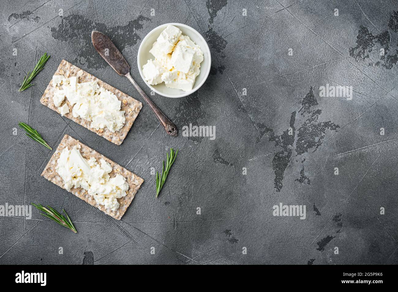 Crisp bread with cream cheese set, on gray stone table background, top ...