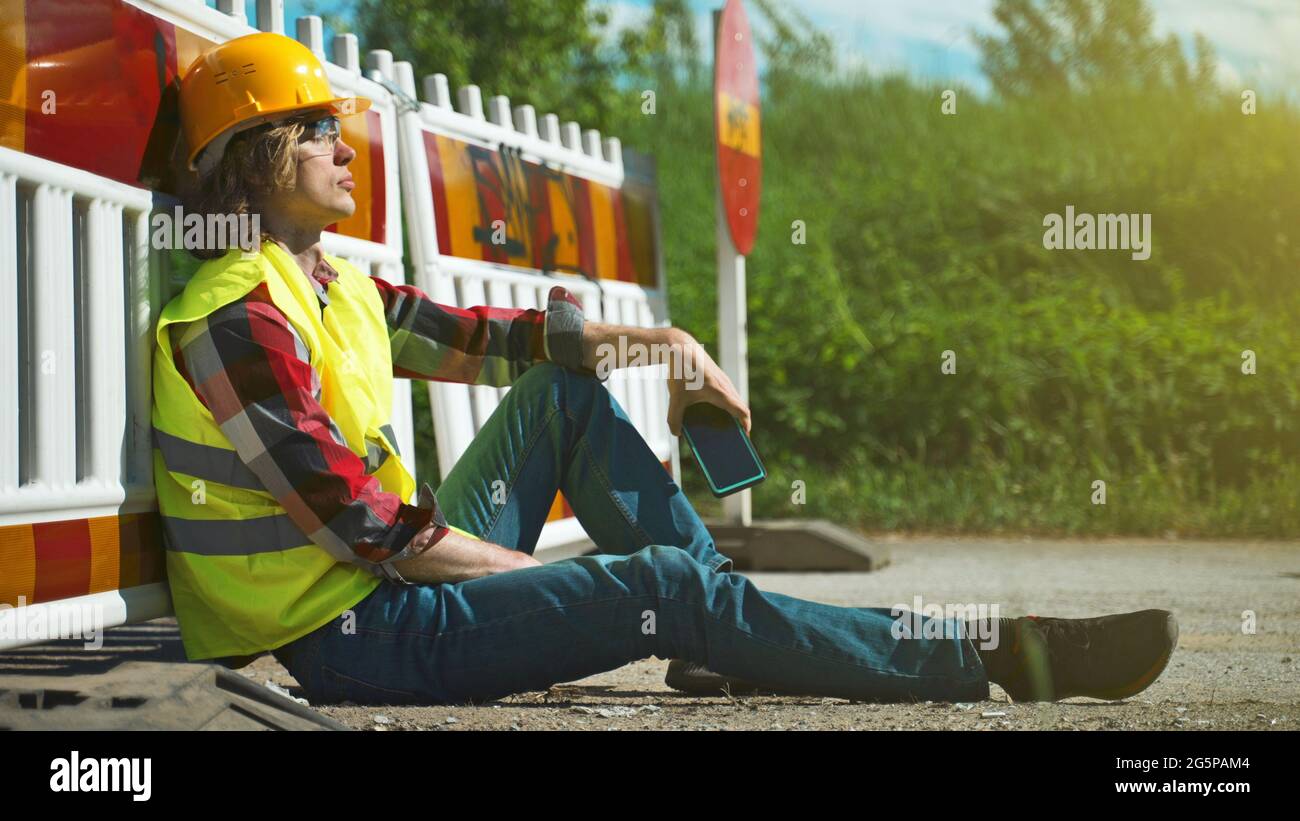 Tired male worker using smartphone on a break. Stock Photo