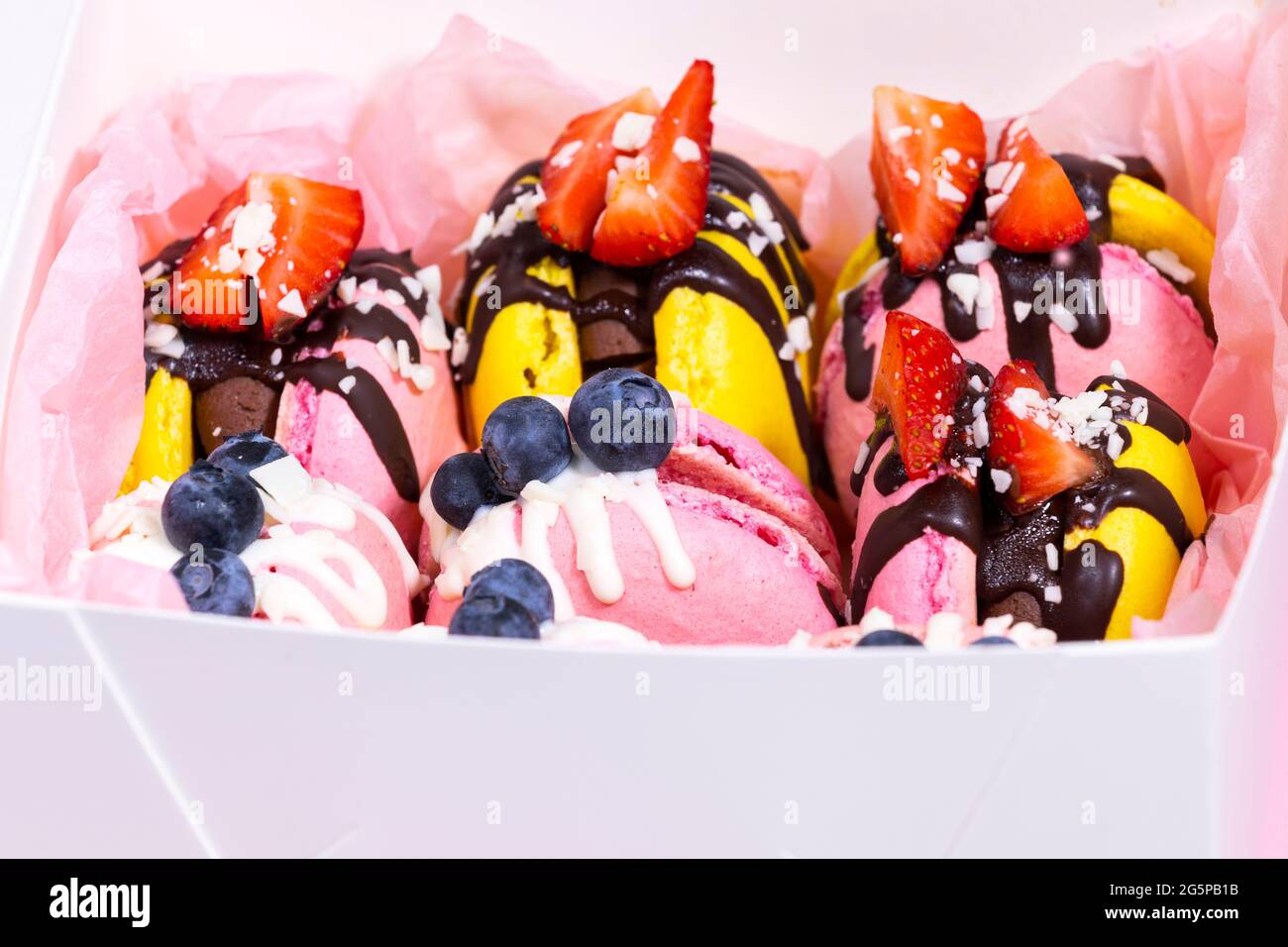 Traditional French Macaroons with bluebarry and strawberry. Colourful and Delicious dessert with chocolate. Close up, top view. Stock Photo