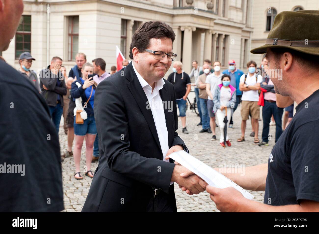 29 June 2021, Saxony-Anhalt, Halle (Saale): Members of the IG 'Agriculture Connects' present Christian Tietje (M), Rector of Martin Luther University, with a joint letter from farmers from Saxony-Anhalt and students at Martin Luther University (MLU). Farmers from Saxony-Anhalt and students of the university (MLU) demonstrate together against the cutback plans of the university, which would also affect the department of agricultural science. Photo: Johannes Stein/dpa-Zentralbild/dpa Stock Photo
