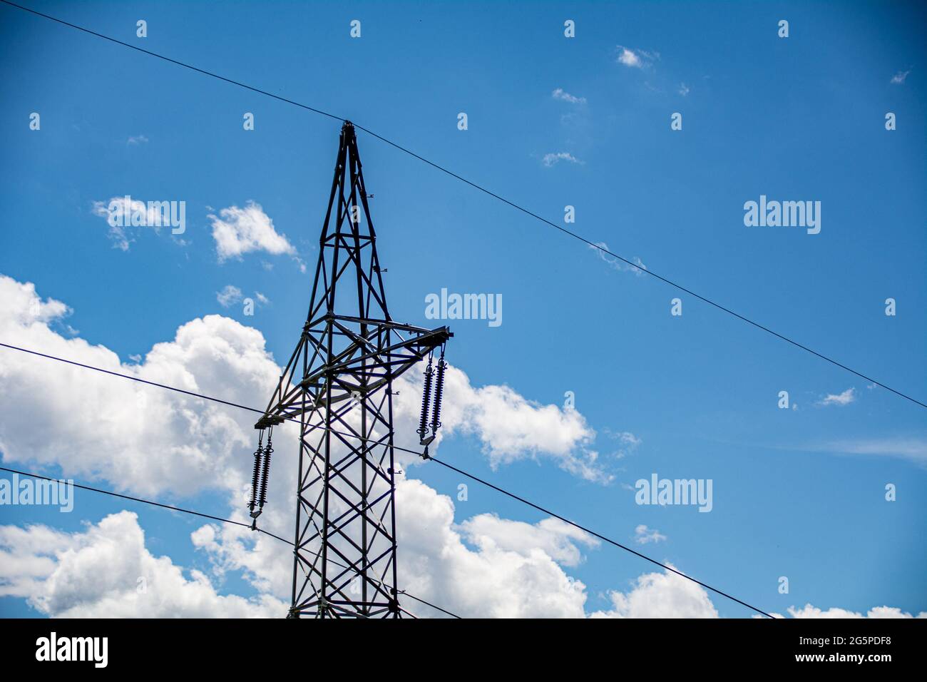 High voltage electric pole against a blue sky Stock Photo - Alamy
