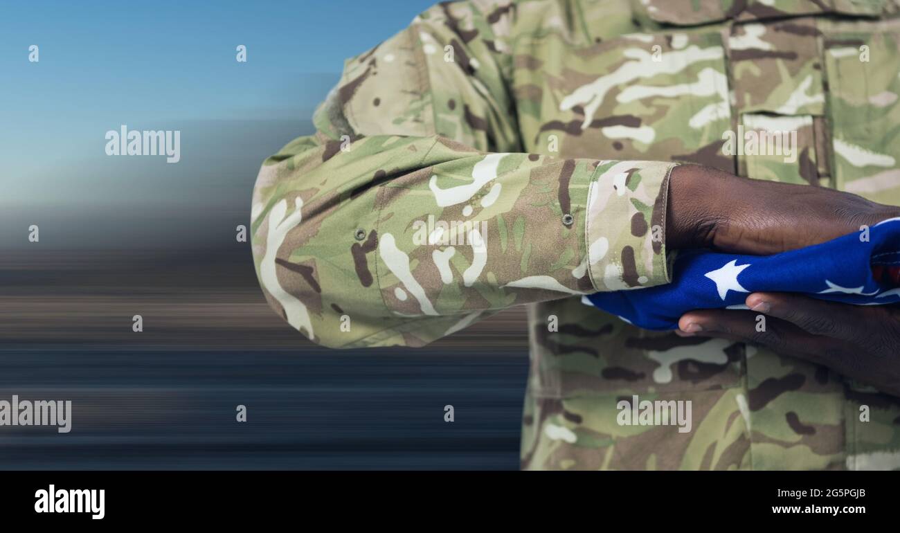 Composition of midsection of soldier with hand on folded american flag ...