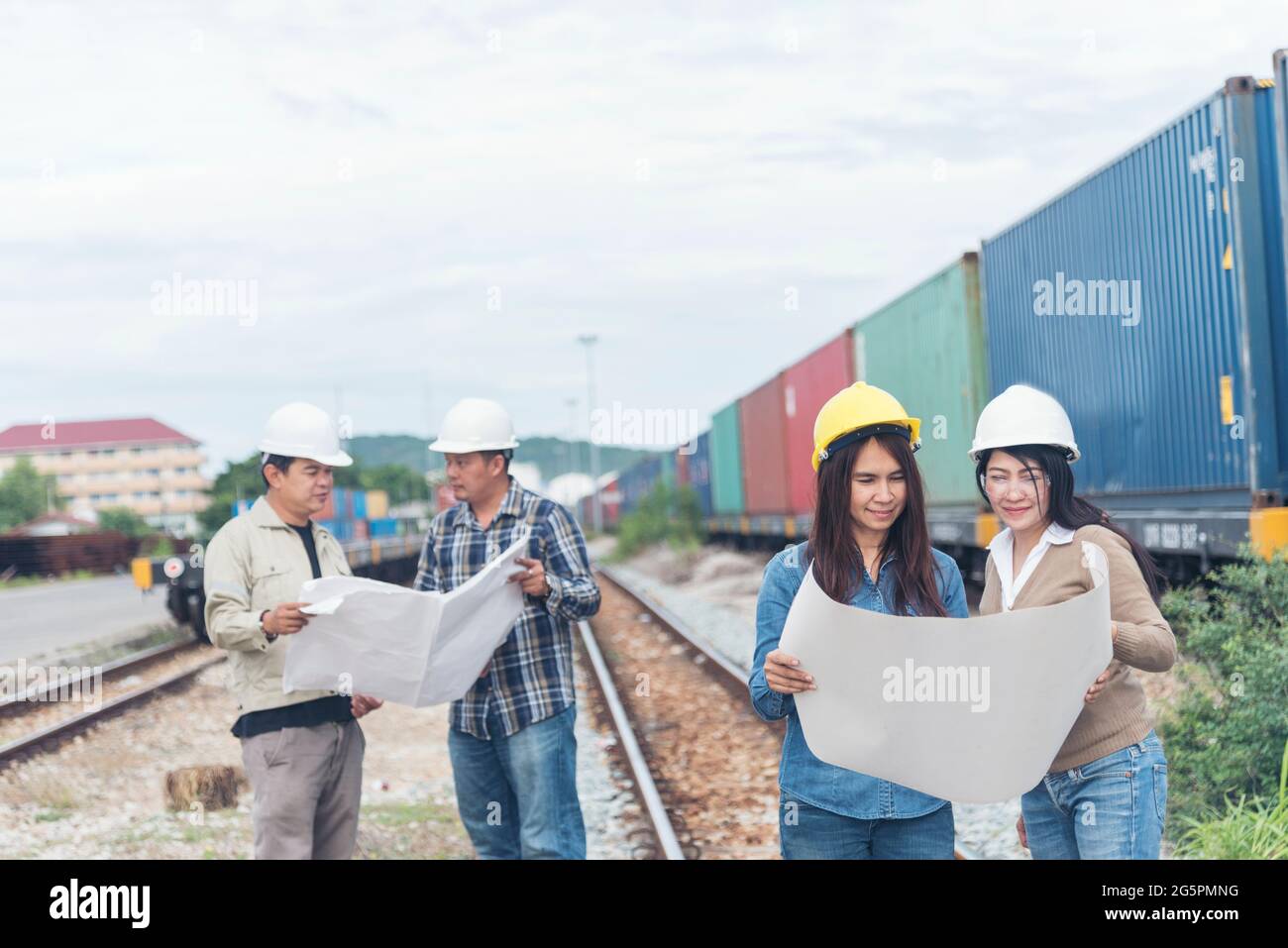 Civil Engineer Team holding blueprint plan for project on site working at railway track Manufacturing Industry Plant. Industry Engineering Concept. Stock Photo