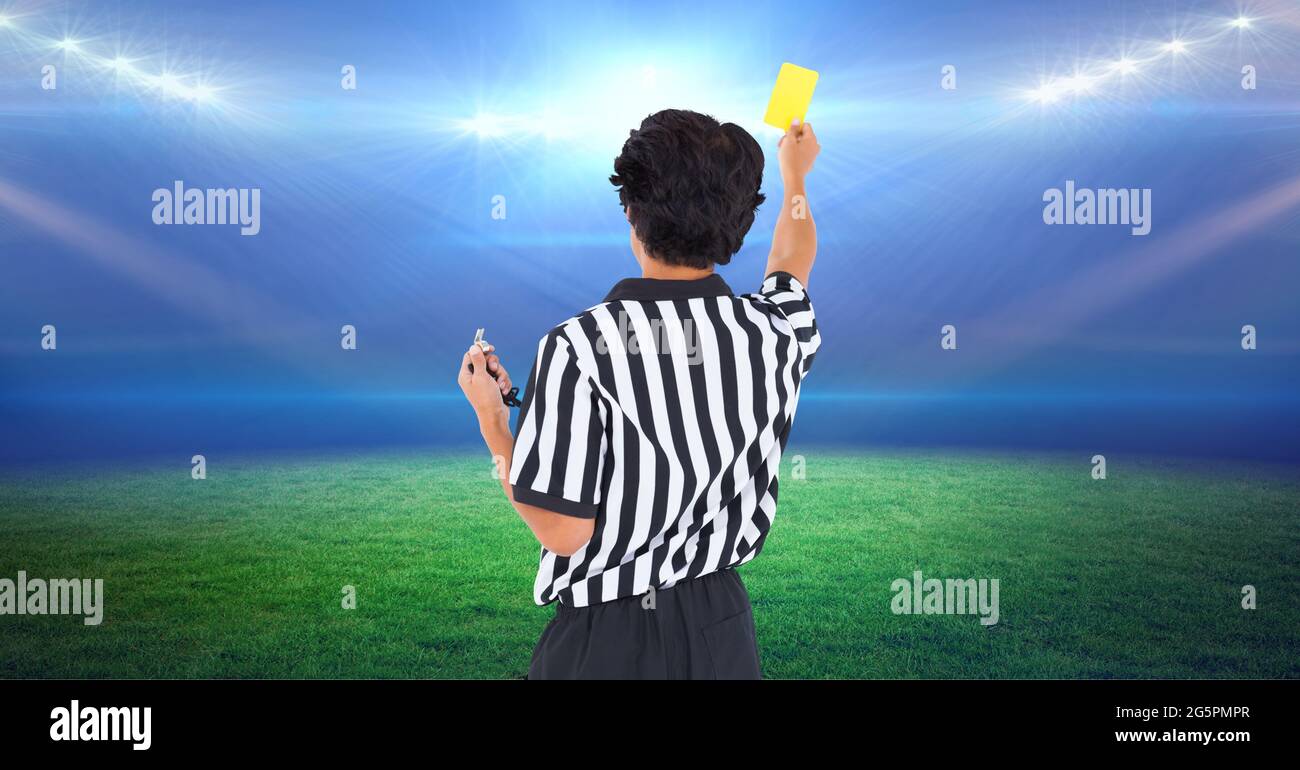 Composition of male referee with yellow card at football stadium Stock Photo