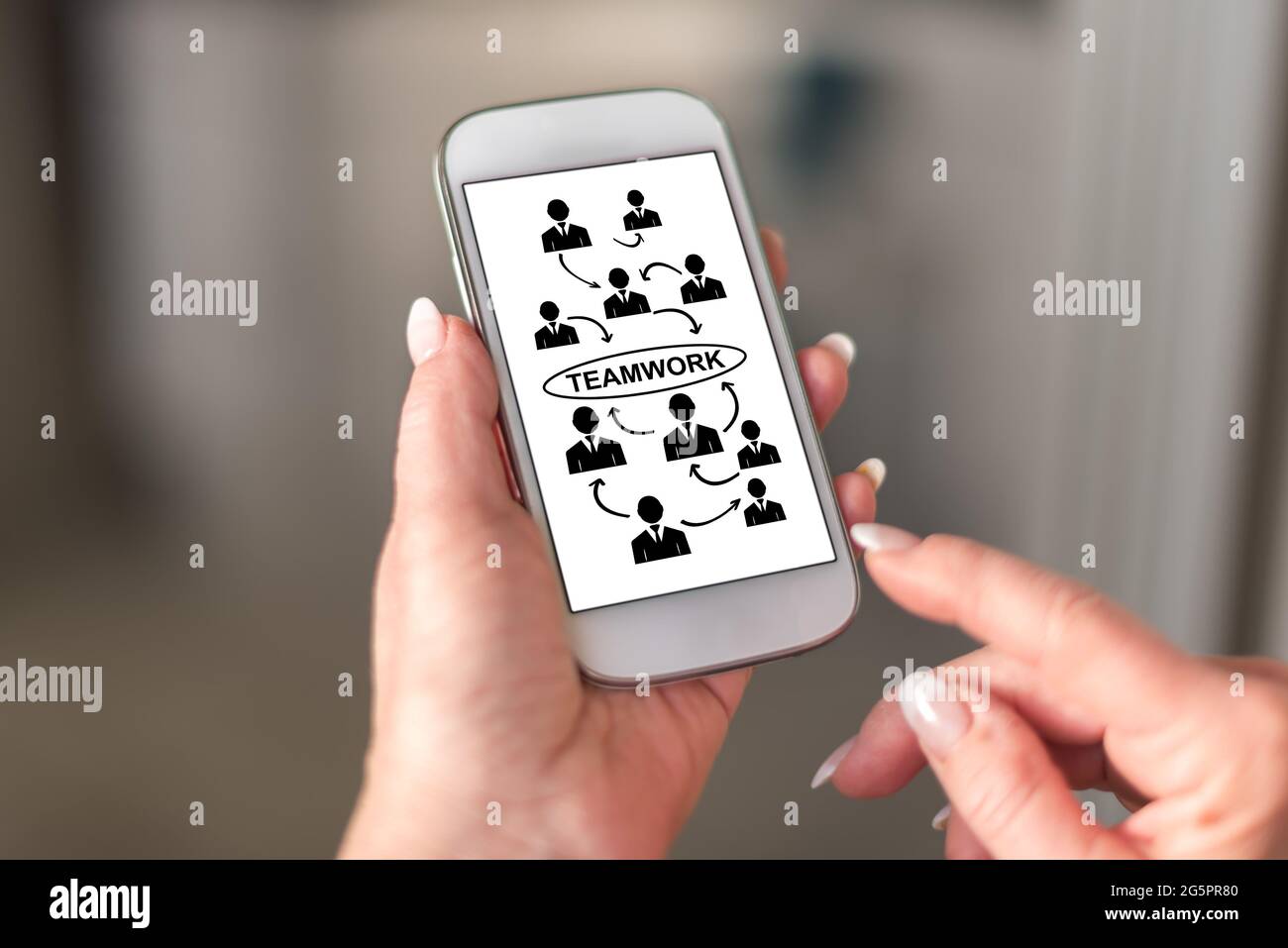 Teamwork concept on a smartphone held by a hand Stock Photo - Alamy