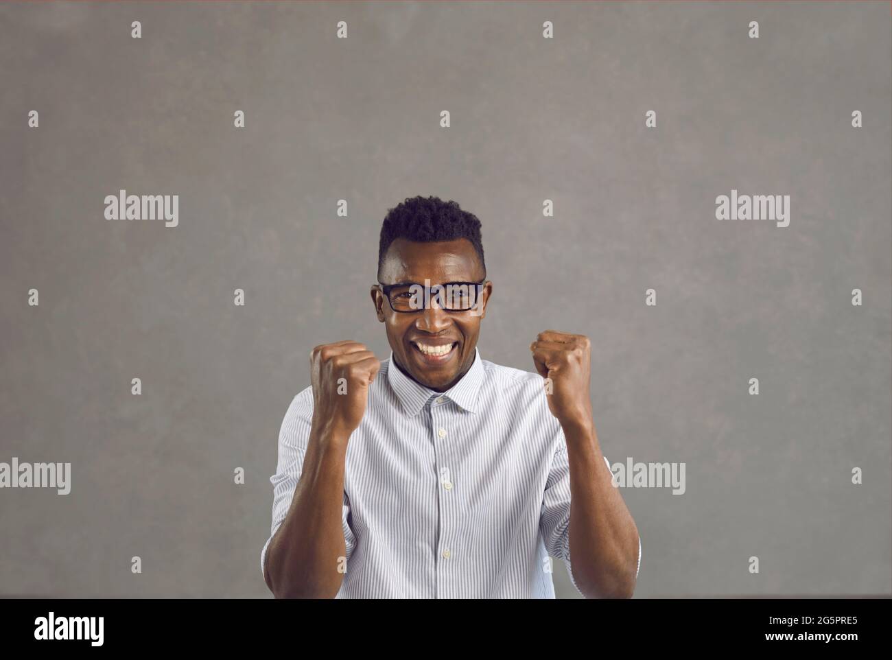 Portrait of overjoyed african american man with clenched fist feeling excited Stock Photo