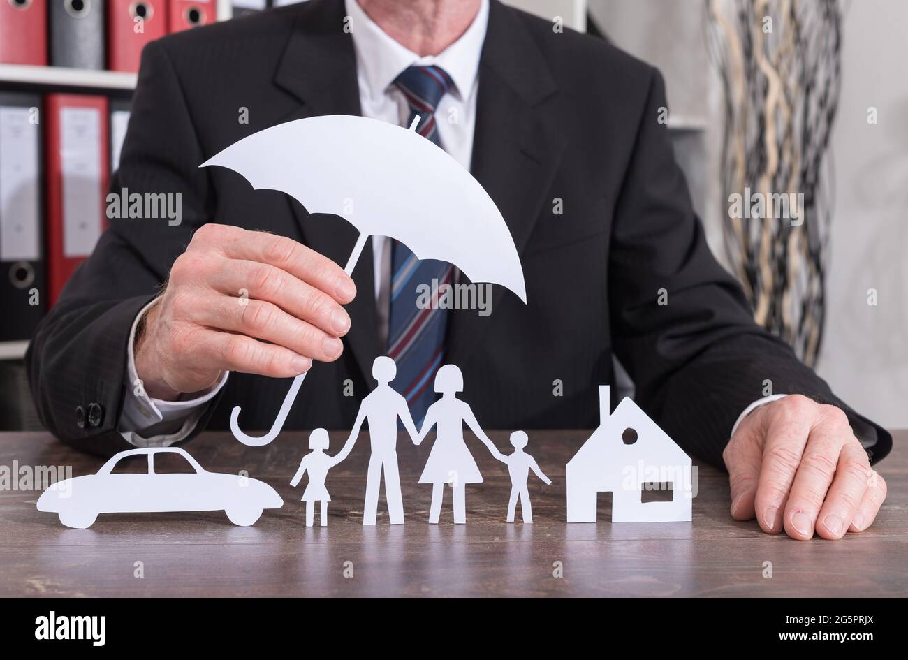 house-car-and-family-protected-with-an-umbrella-by-an-insurer-insurance-concept-2G5PRJX.jpg
