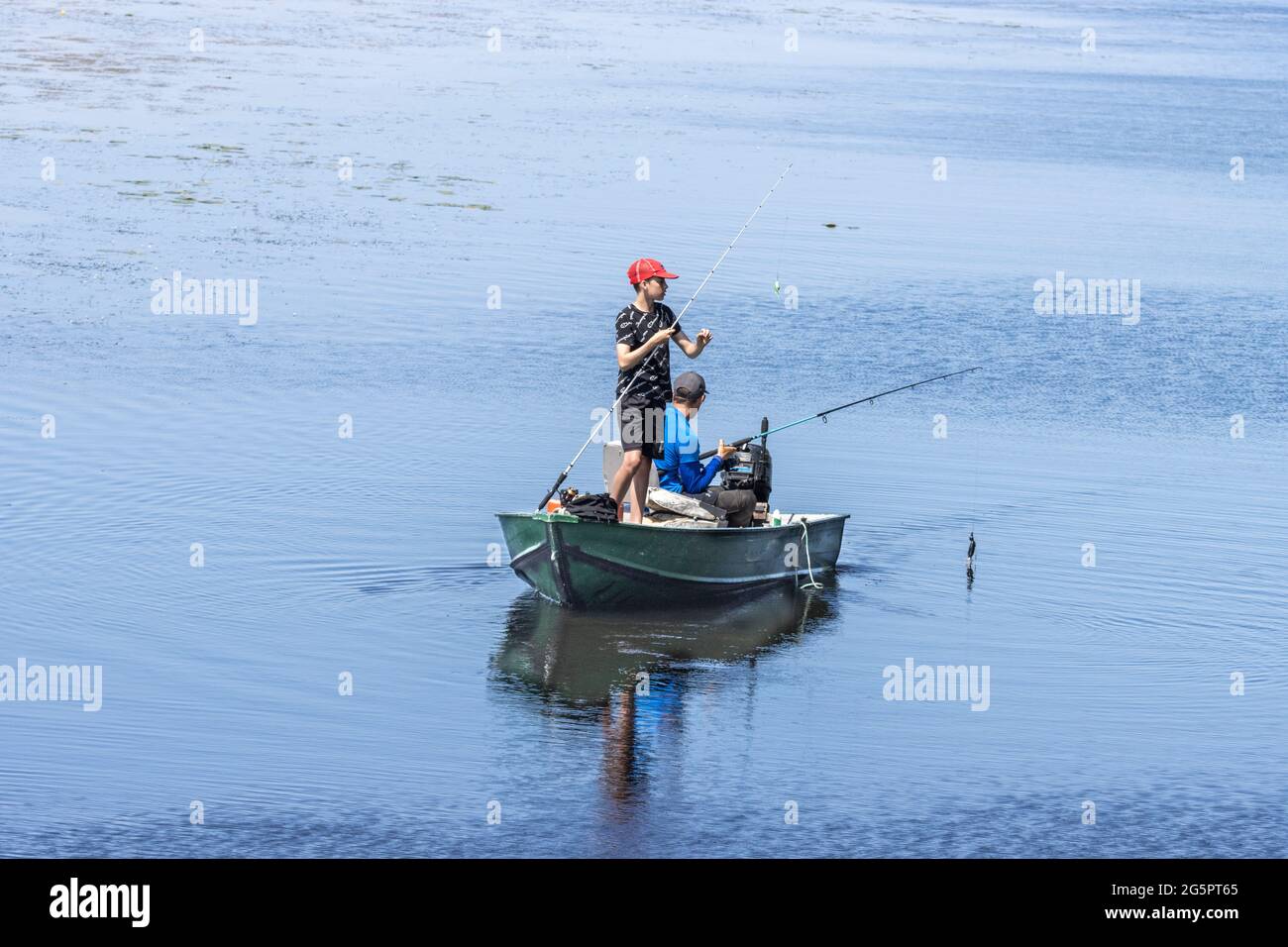 Father and Son fly fishing from a boat in a wetland marsh in Ken Reid Park in Lindsay Ontario Canada Stock Photo