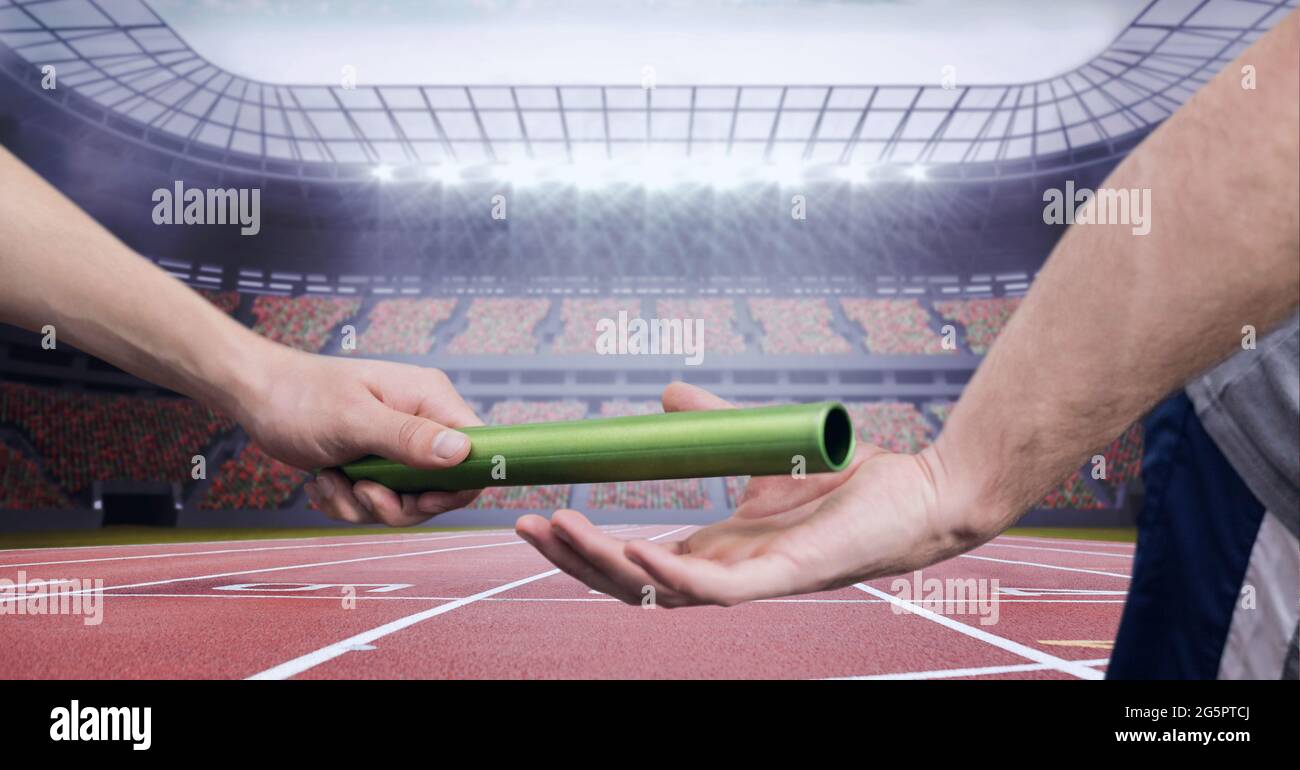 Composition of male runner passing baton to his teammate Stock Photo