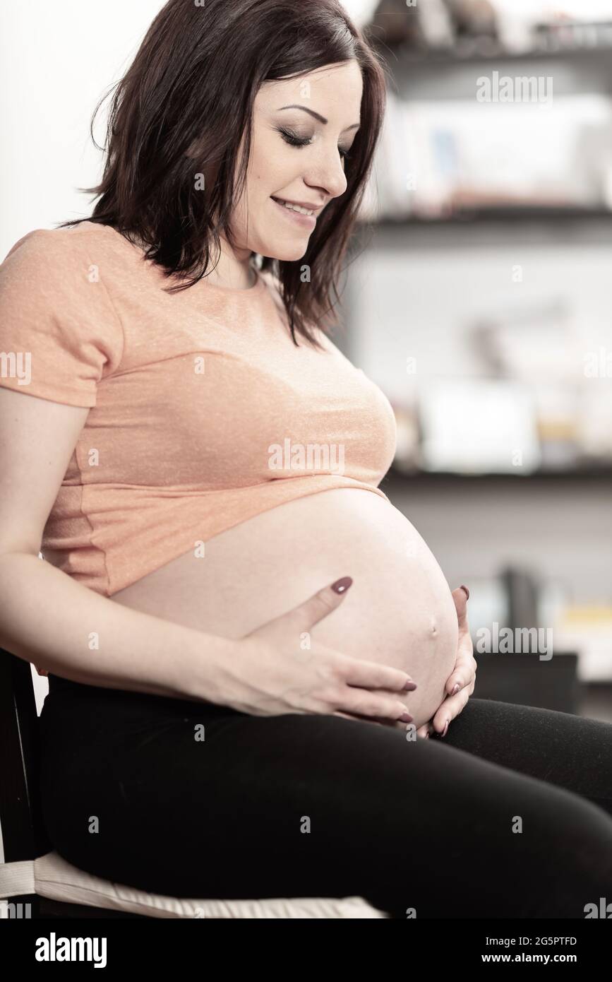 Portrait of pregnant woman holding hands on her belly Stock Photo - Alamy