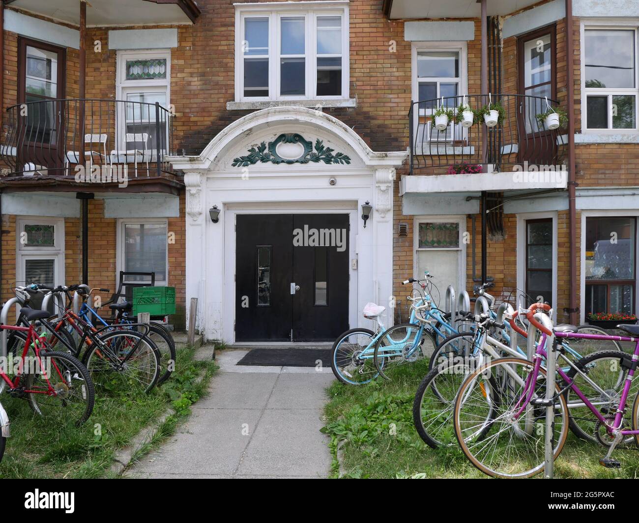 Old apartment building with bicycle stands in front yard Stock Photo