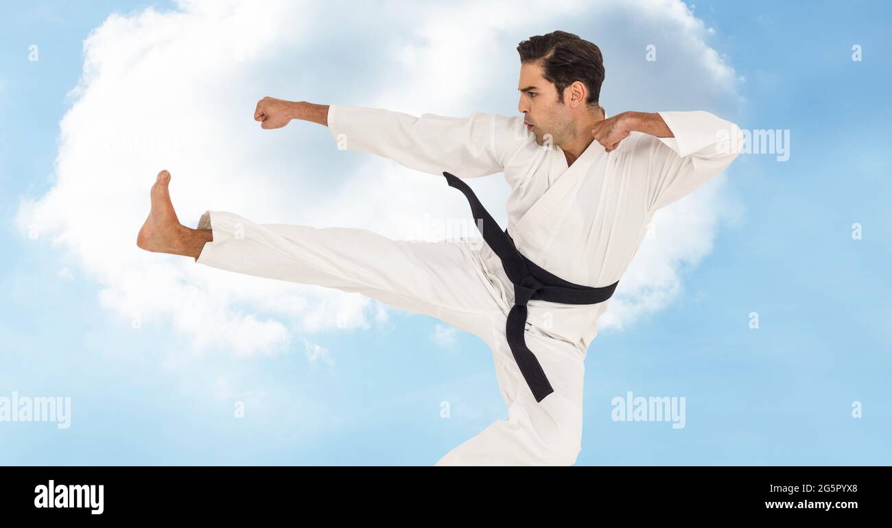 Digital composite image of caucasian male marital artist with black belt against blue sky Stock Photo