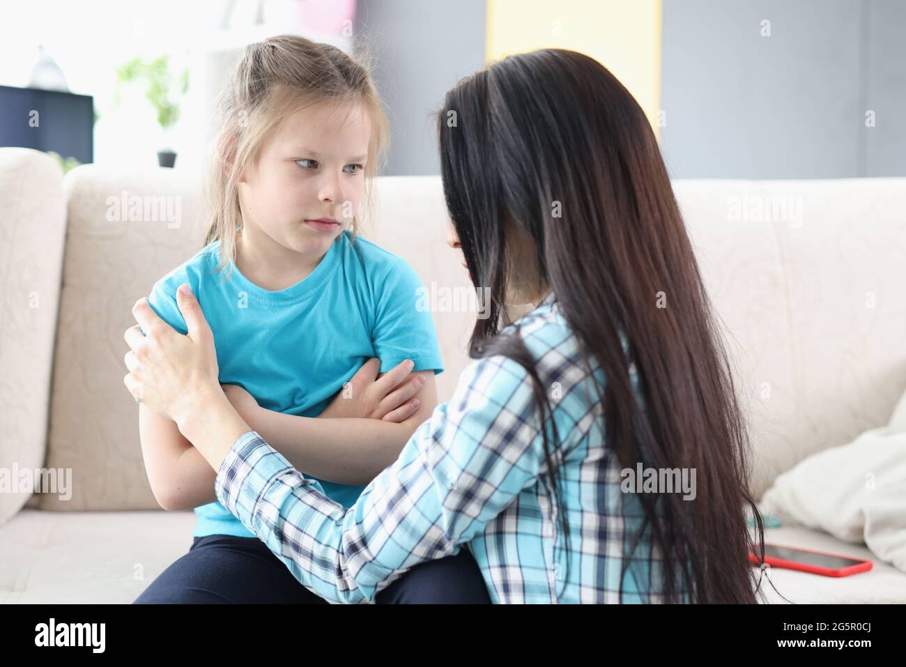 Llittle offended girl communicates with mother at home Stock Photo