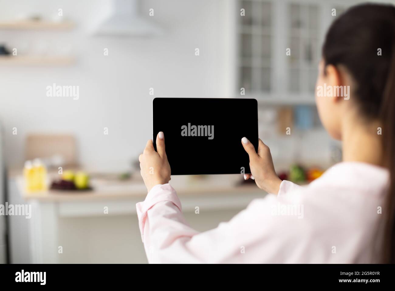 Lady using digital tablet with blank empty screen, mock up Stock Photo