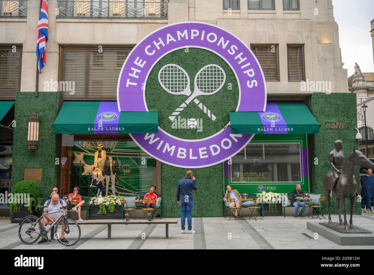New Bond Street, London, UK. 29 June 2021. Day 2 of the Wimbledon grand slam Tennis Championships with people enjoying the Ralph Lauren outdoor cafe dressed in grass and Wimbledon colours in central London’s fashionable shopping street. Credit: Malcolm Park/Alamy Live News Stock Photo