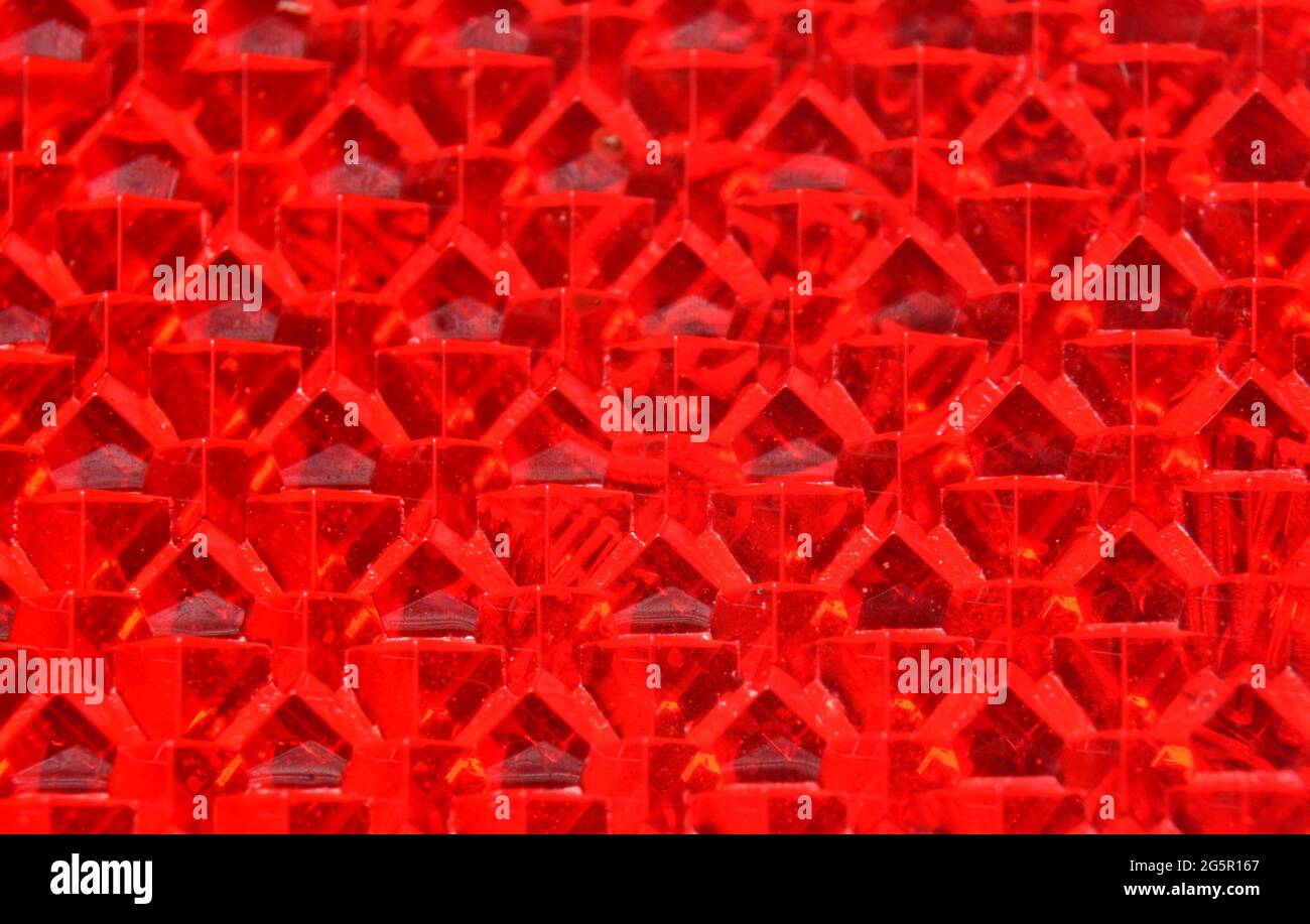 Abstract red tetraeder pattern which is actually the rear side of a red reflex plate. Stock Photo