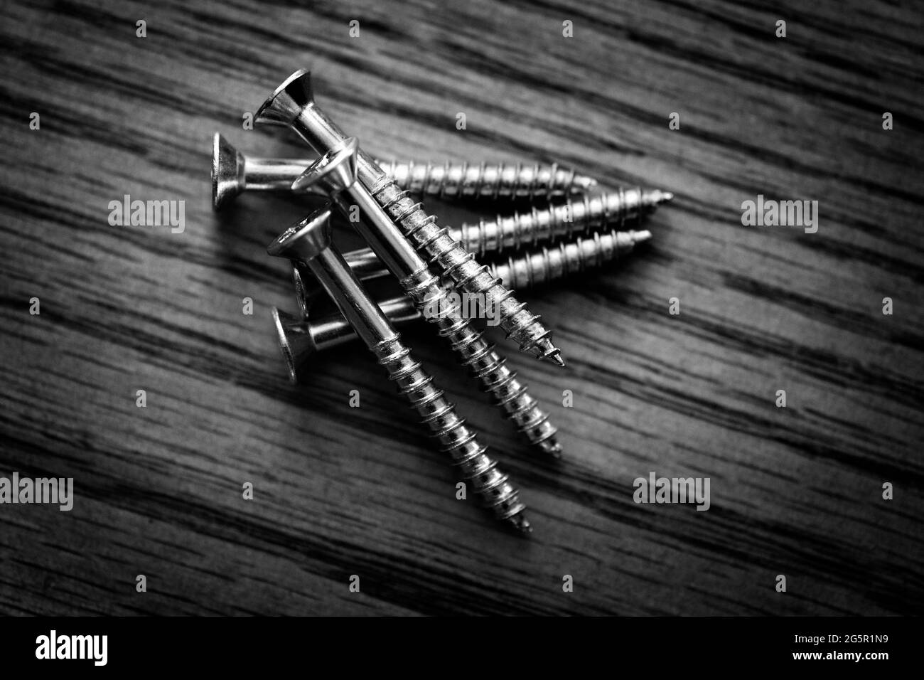 Screws pile of on wood tabletop workbench work bench for fixing Stock Photo
