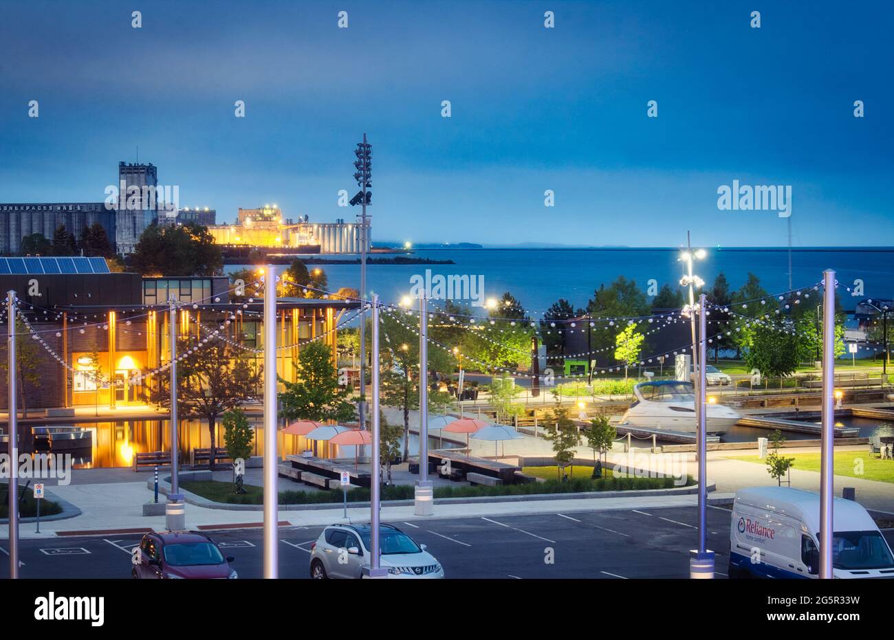 Thunder Bay waterfront cityscape at night, with restaurant and marina in foreground, grain elevator, port terminal, and Sleep Giant Provincial Par Stock Photo