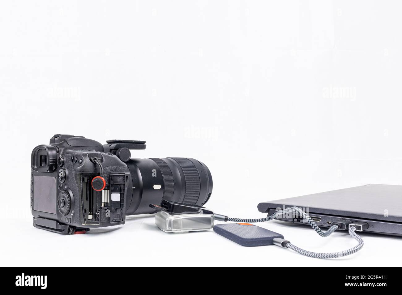 photo processing workstation with a laptop, dslr, cf card reader and ssd disc drive on a white background with copy space Stock Photo