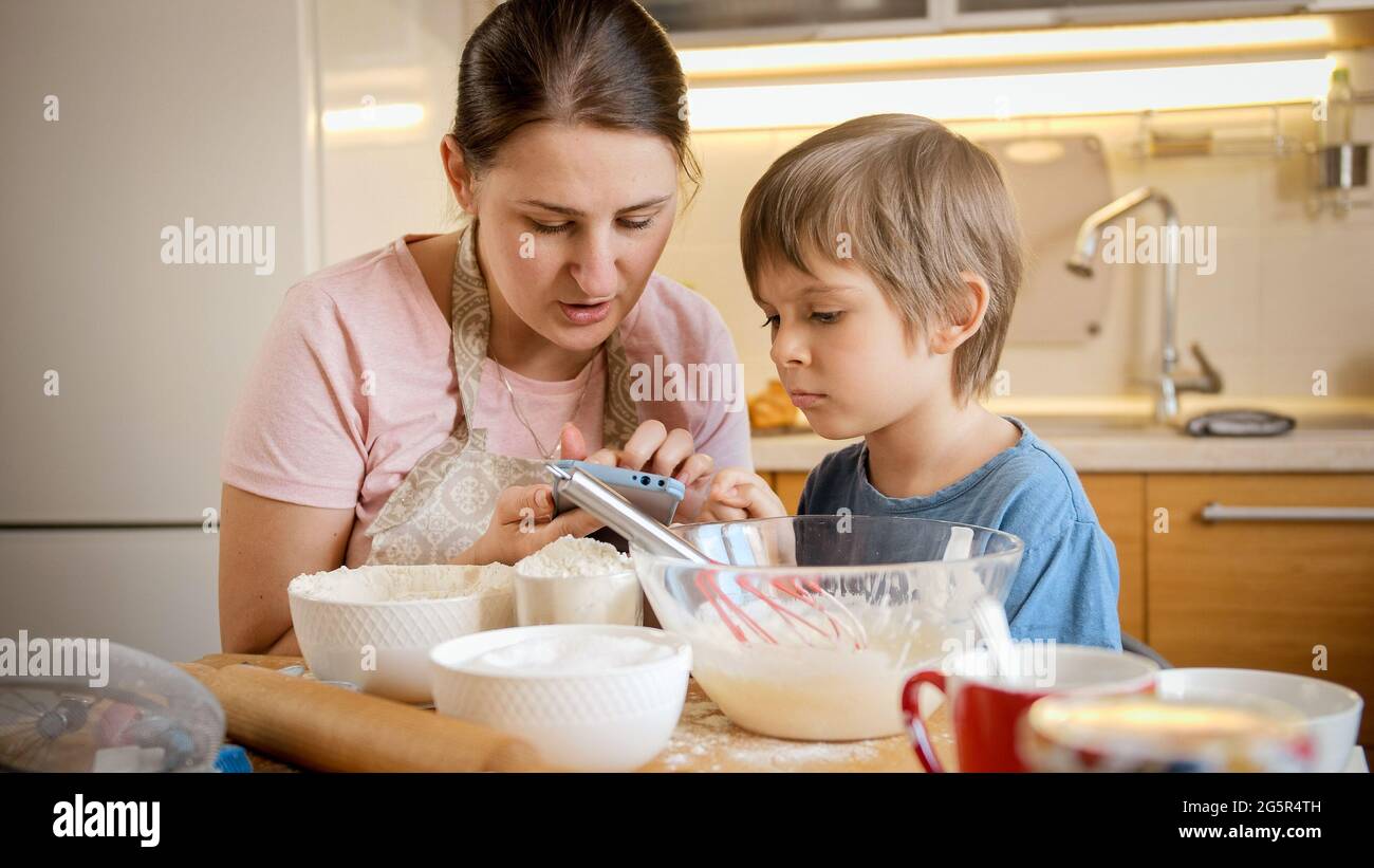 https://c8.alamy.com/comp/2G5R4TH/young-mother-with-little-boy-looking-in-recipe-on-smartphone-for-making-biscuit-at-home-children-cooking-with-parents-little-chef-family-having-2G5R4TH.jpg