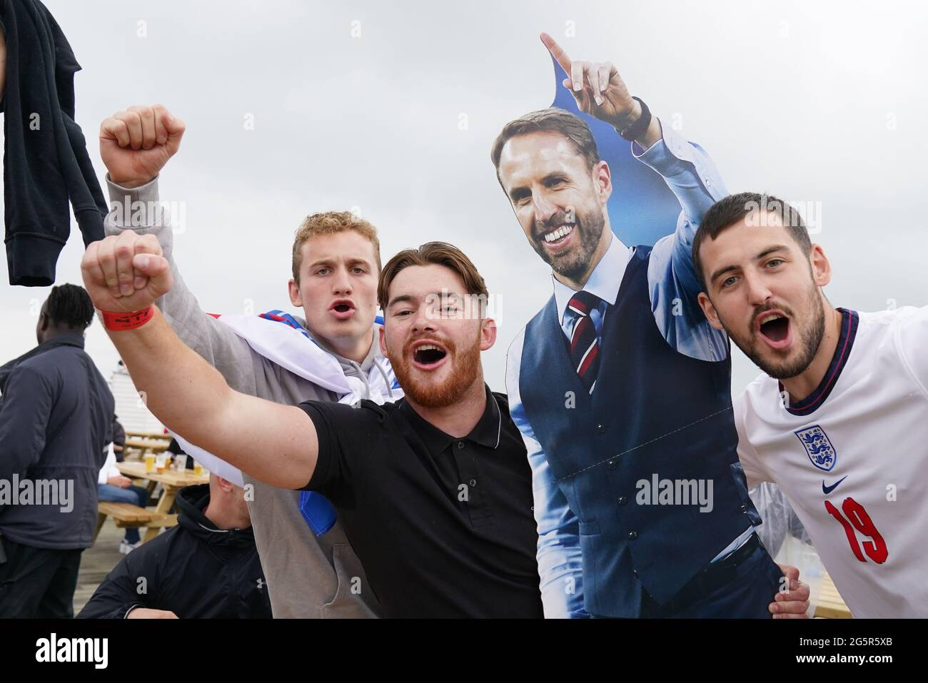 Fans with a Gareth Southgate cardboard cutout before they watch the